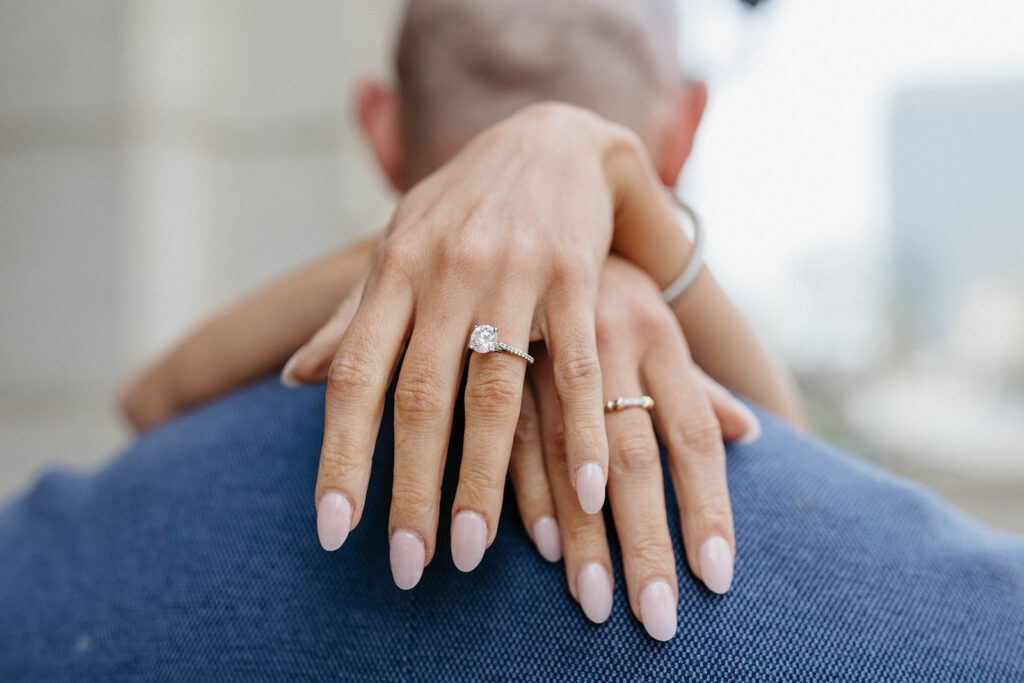 couple hugging engagement ring photos