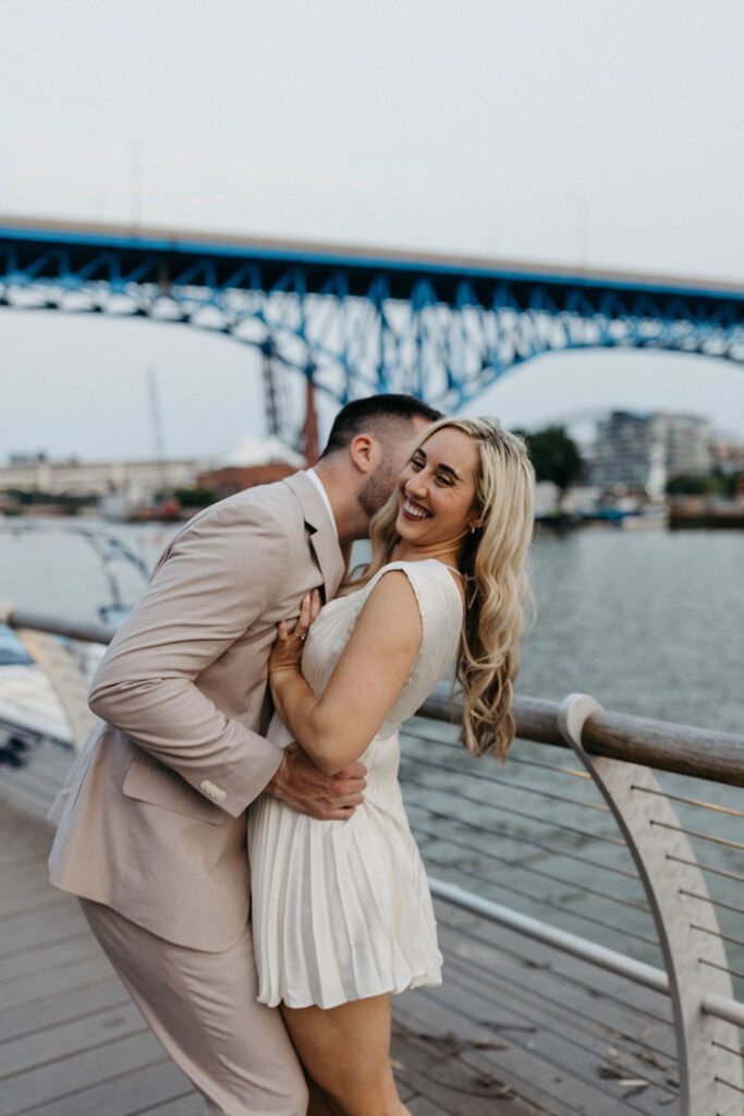 couple kissing in front of lake in downtown cleveland