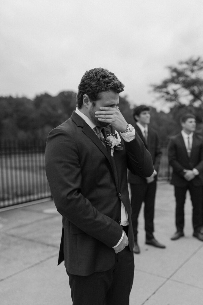 groom watching bride walk down the aisle during ceremony