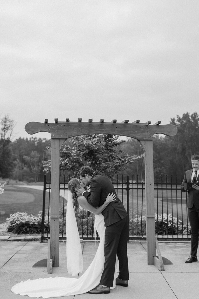 bride and groom kissing during wedding ceremony