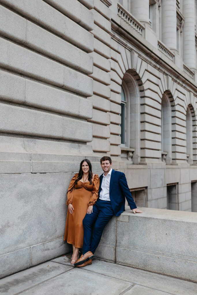 couple leaning against wall for engagement photos