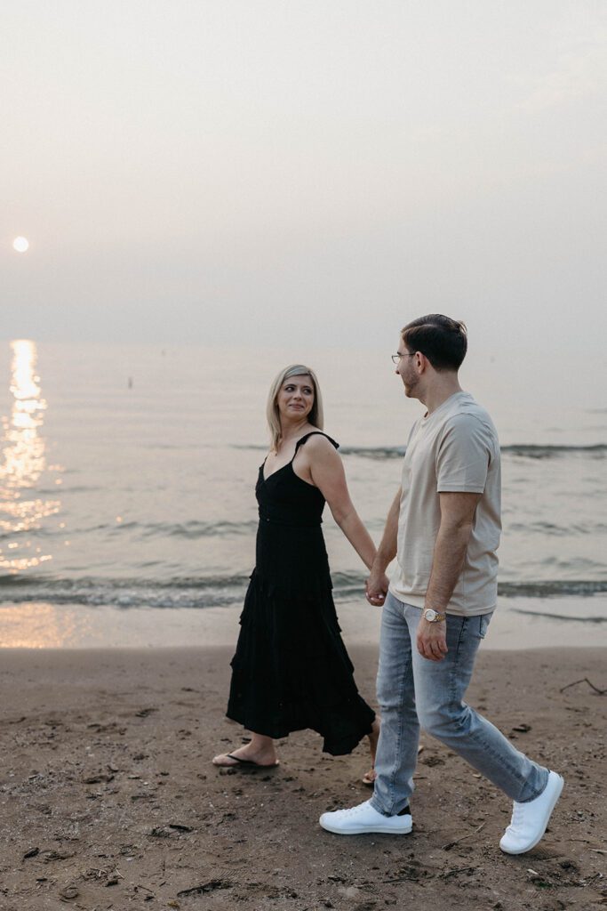 couple holding hands walking on the beach