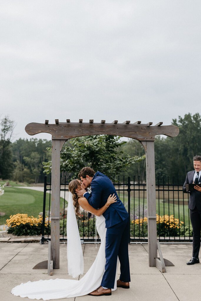 bride and groom first kiss during wedding ceremony