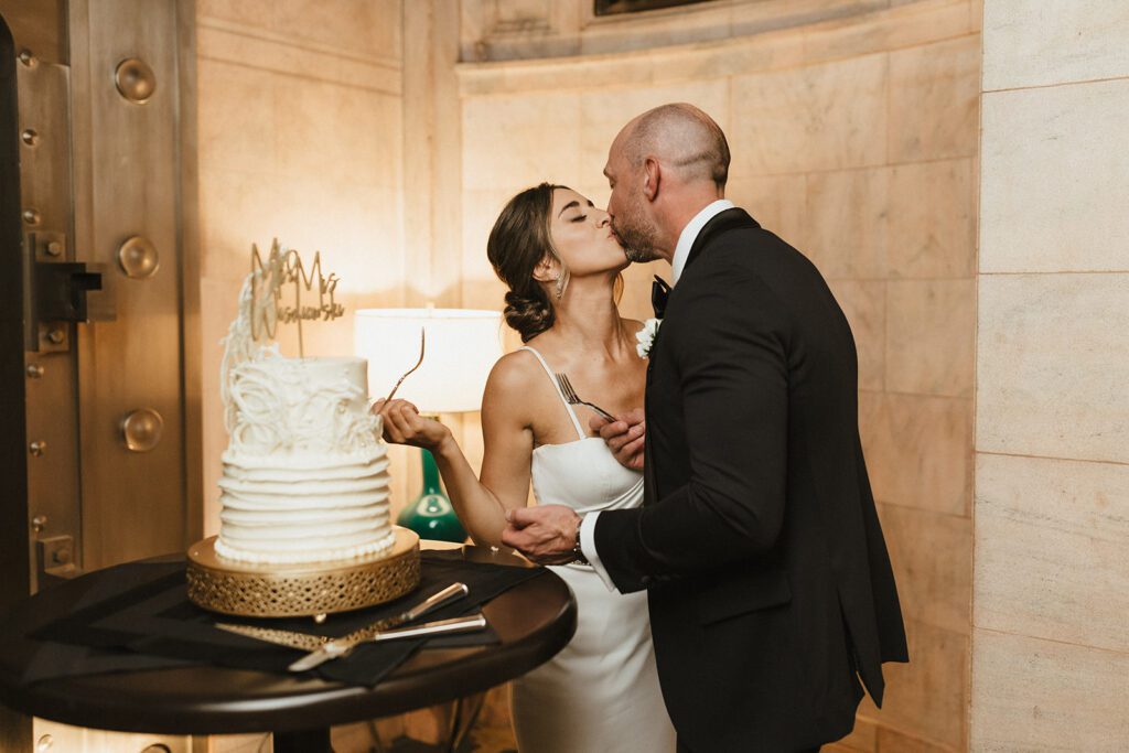bride and groom kissing cake cutting