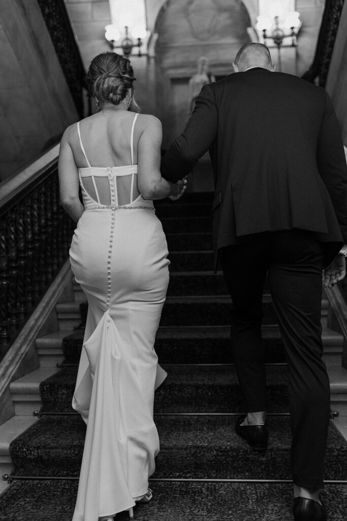 bride and groom walking up stairs black and white