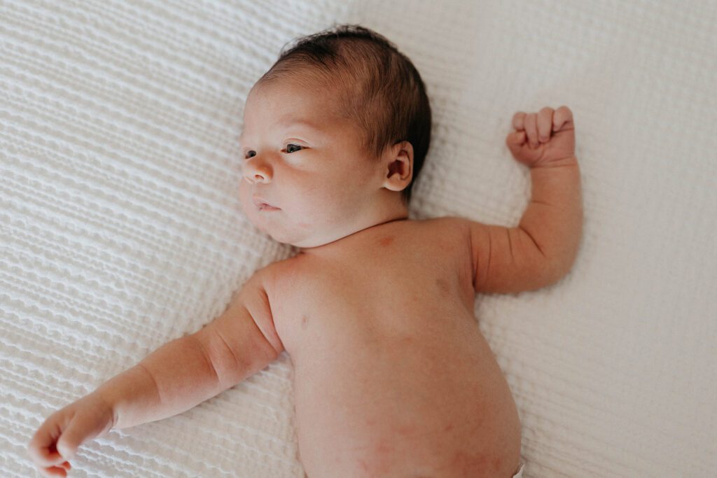 lifestyle newborn session photos with baby on bed