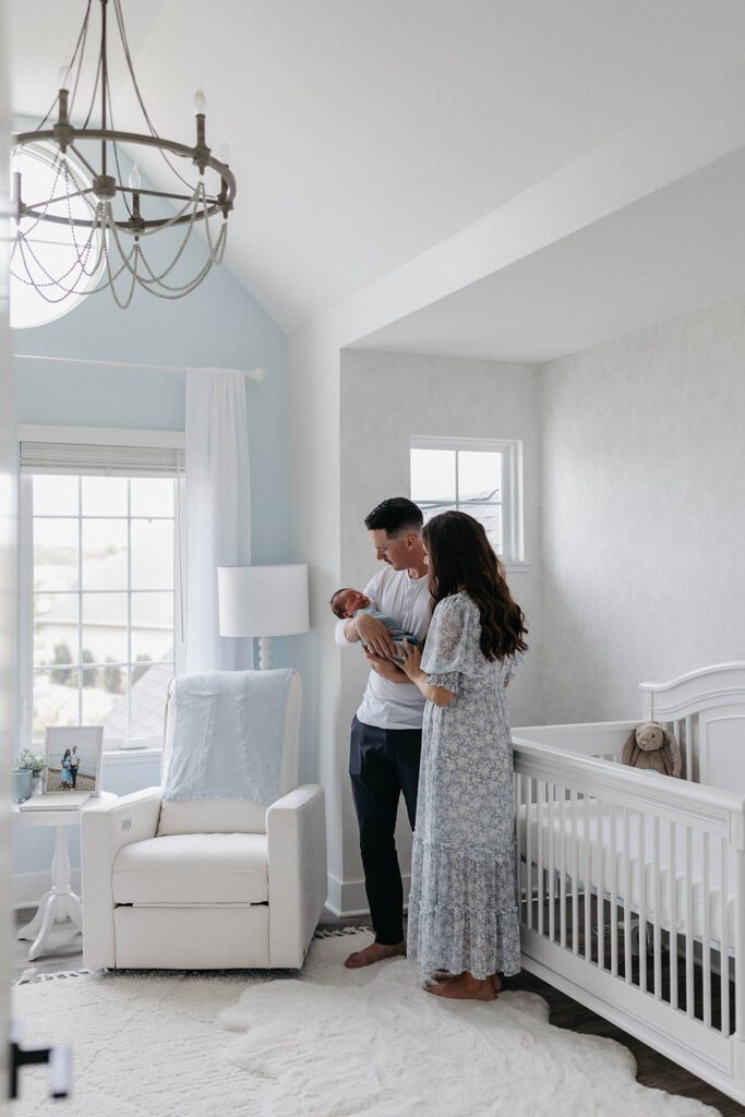 couple holding newborn baby in nursery