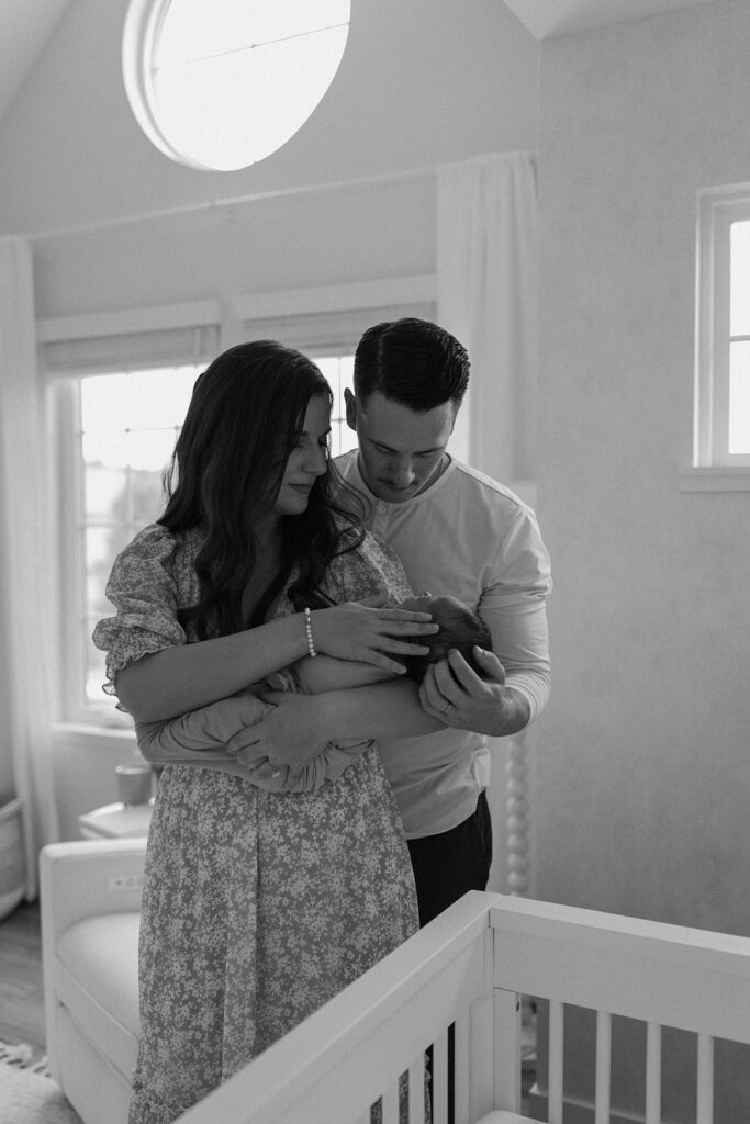 couple holding newborn baby in nursery