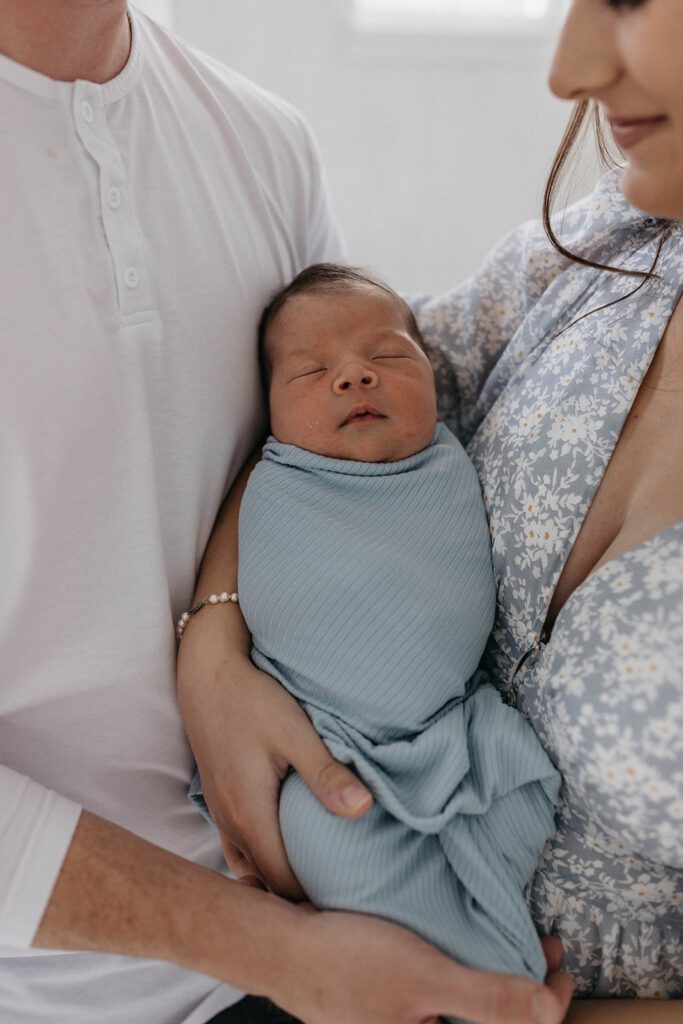 couple holding newborn baby in nursery