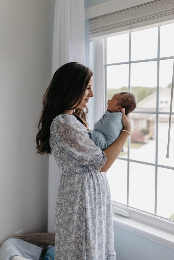 wife posing for family photos with newborn in home