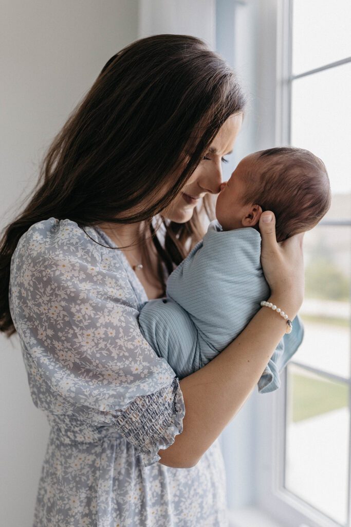 wife posing for family photos with newborn in home