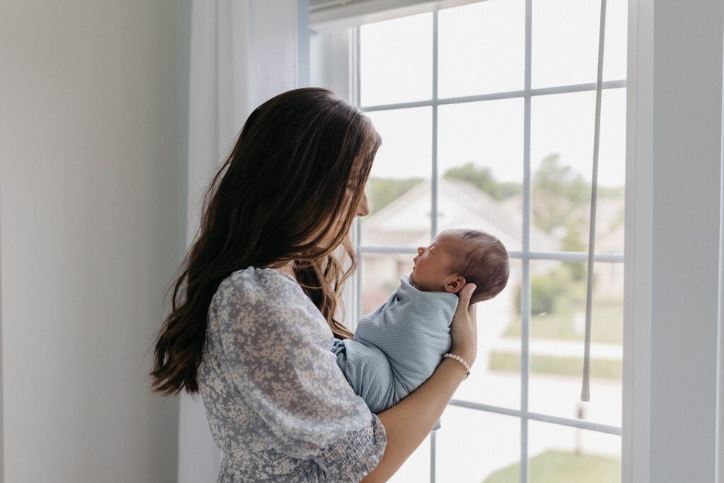 wife posing for family photos with newborn in home