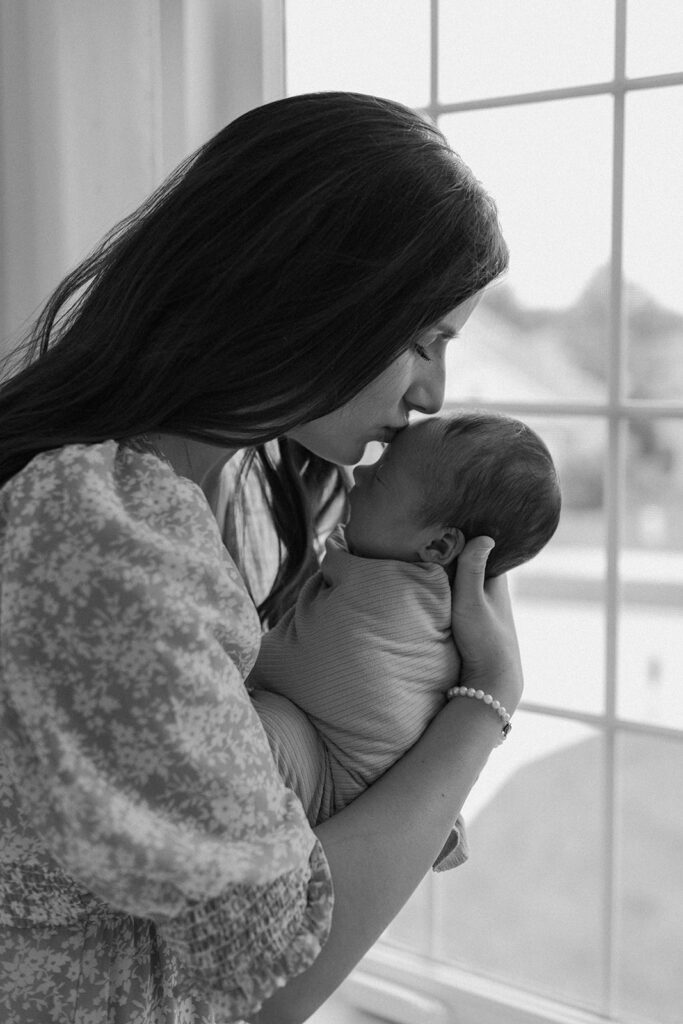 wife posing for family photos with newborn in home