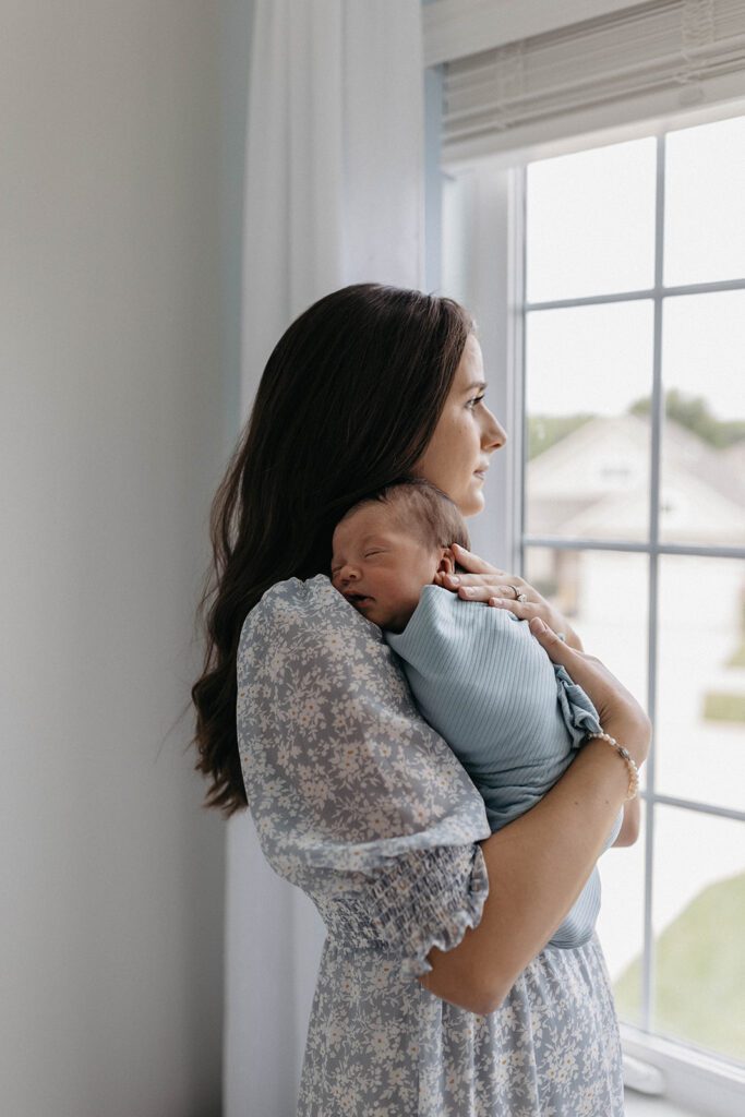 wife posing for family photos with newborn in home