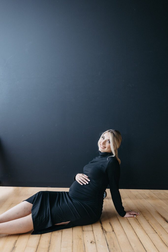 wife holding pregnant belly for studio photoshoot