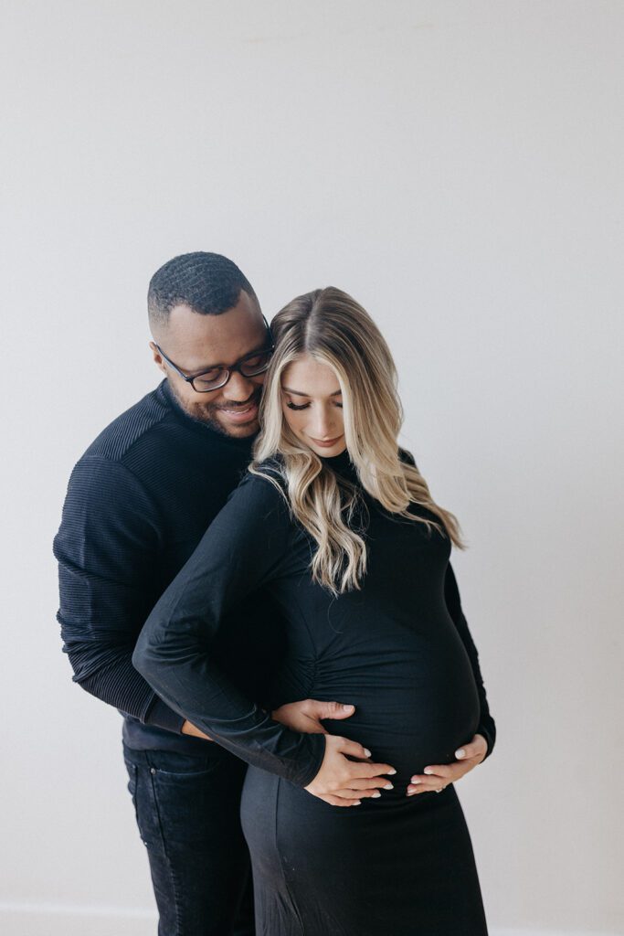 husband holding wifes belly during maternity session