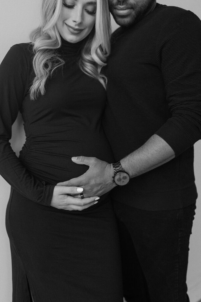 couple holding pregnant belly for maternity photos